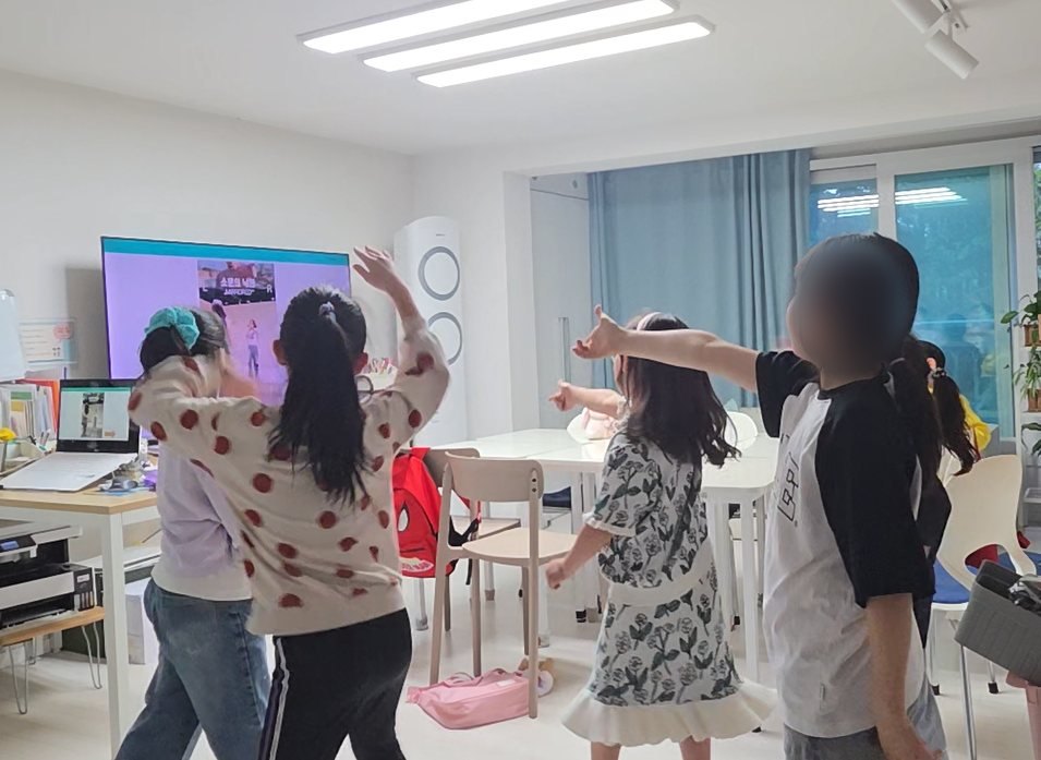 교실에서 함께 율동하며 활동하는 학생들